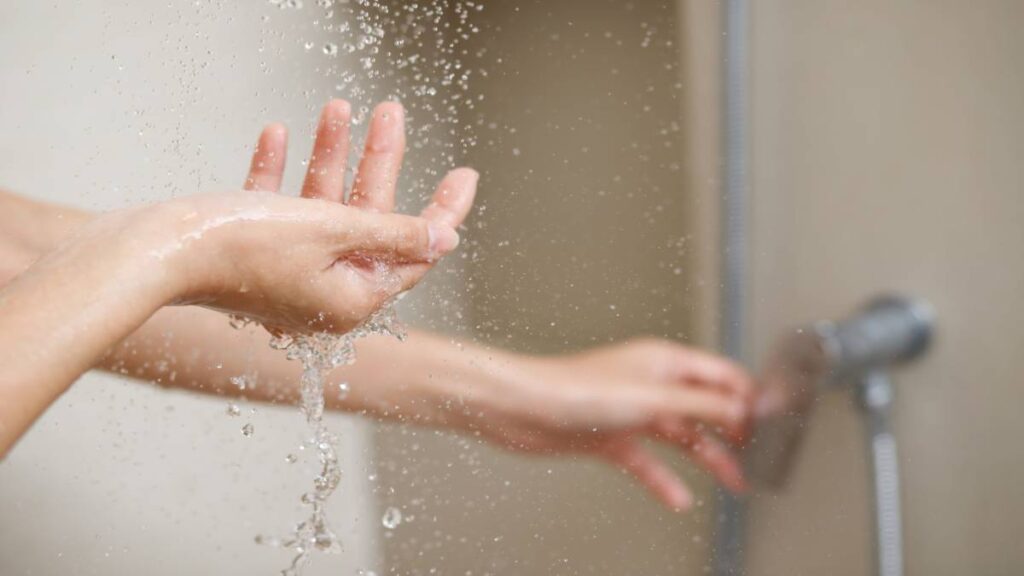 Detail van handen in een douche.