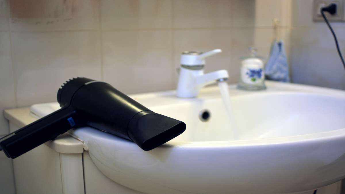 Een haardroger naast een lavabo: een potentieel gevaarlijke mix van water en elektriciteit in de badkamer.