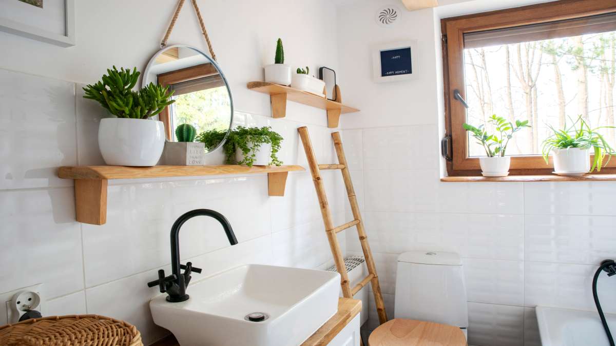 Een kleine badkamer met een enkele opbouw wastafel op een houten badkamermeubel. 