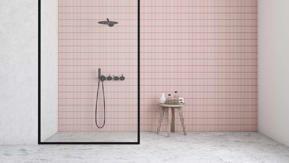 We zien een minimalistische inloopdouche met een mooi betegelde roze muur.