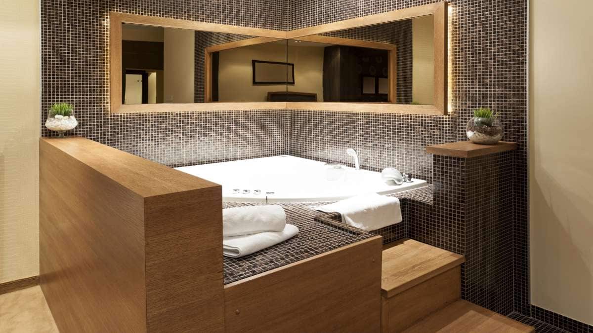 Je ziet hier een massage bad geplaatst in de hoek van een badkamer.