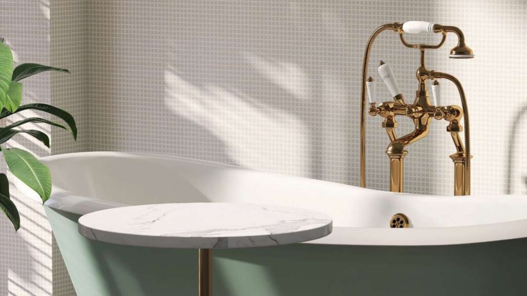 Moderne badkamer met badkuip met daaraan een gouden douchekraan.