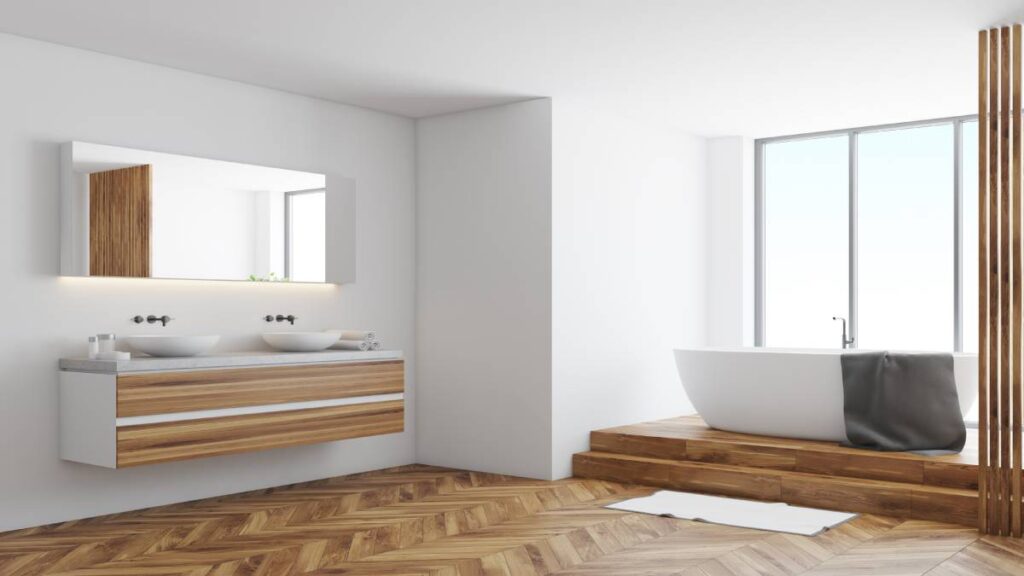 De moderne badkamer beschikt over een laminaatvloer en een combinatie van witte en houten accenten, die samen een ontspannen sfeer creëren.